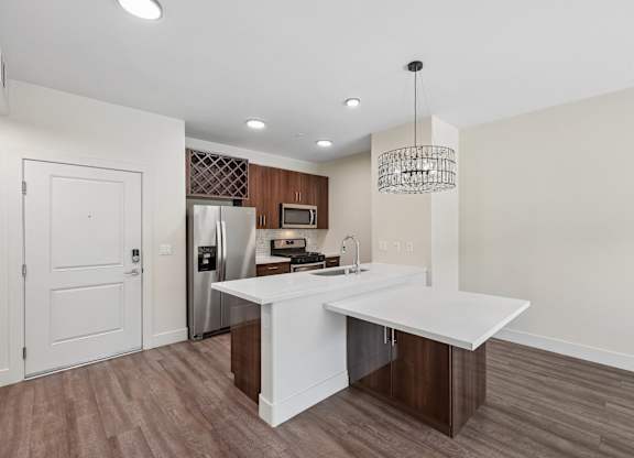 A kitchen with a white island and a refrigerator.