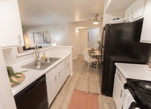 a kitchen and dining room with a black refrigerator and sink at Austin Crest Apartments, Reno, 89523