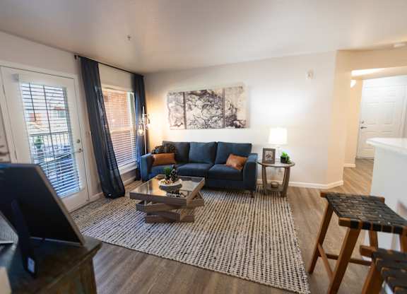 A living room with a blue couch and a coffee table.
