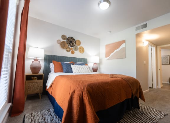 a bedroom with a bed and two lamps and a window at Austin Crest Apartments, Reno, 89523