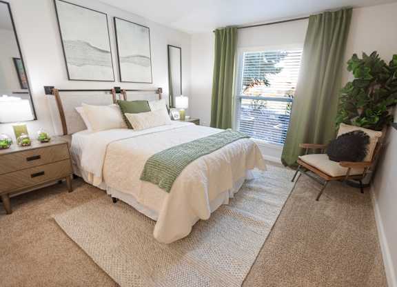 A bedroom with a large bed and a chair.