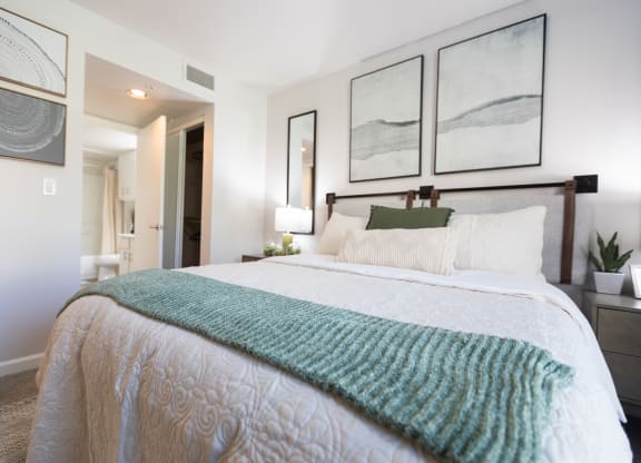 a bedroom with a large bed and pictures on the wall at Austin Crest Apartments, Reno