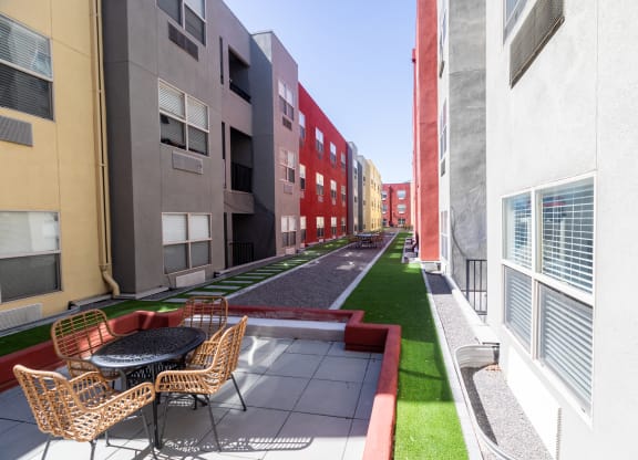 a rendering of a courtyard between two buildings with chairs and a table at ParcOne60, Nevada, 89501