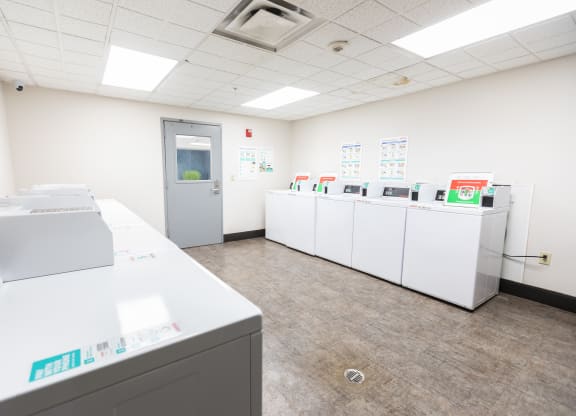 a laundry room with washers and dryers and a door to a hallway at ParcOne60, Reno, 89501
