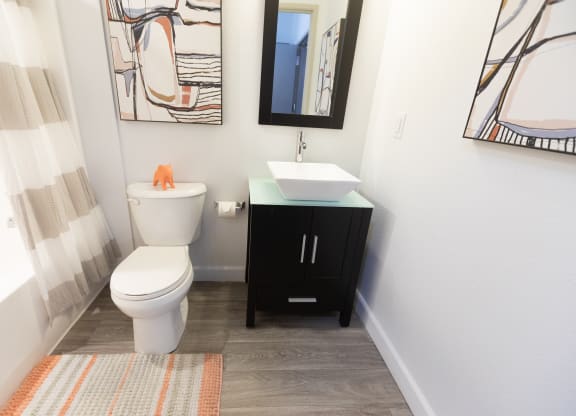 a bathroom with a toilet and a sink and a mirror at ParcOne60, Reno, 89501
