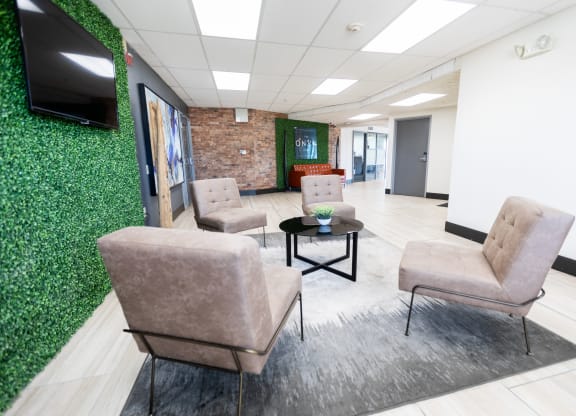 a waiting room with brown chairs and a green wall at The Onyx at 695, Reno