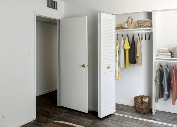 a living room with a couch and a closet at Evoq Apartment Homes, Las Vegas, NV 89169  