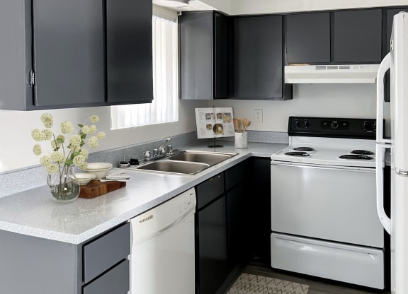 a kitchen with white appliances and black cabinets at Evoq Apartment Homes, Las Vegas, 89169  