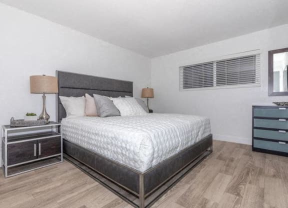 a bedroom with a bed and two night stands at Evoq Apartment Homes, Las Vegas, NV 89169  