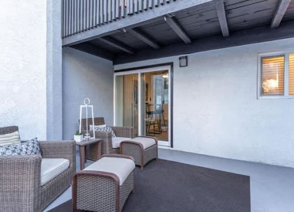 a patio with wicker furniture and a sliding glass door at Evoq Apartment Homes, Las Vegas Nevada  