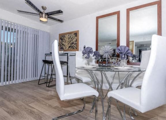 a dining room with a glass table and white chairs at Evoq Apartment Homes, Las Vegas, 89169  