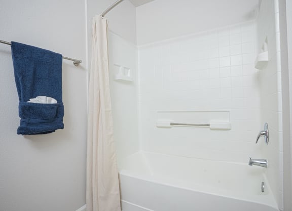 a bathroom with a shower and a blue towel on a rack at Austin Crest Apartments, Reno, NV, 89523