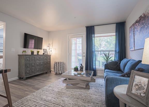 a living room with a blue couch and a tv at Austin Crest Apartments, Reno, NV, 89523