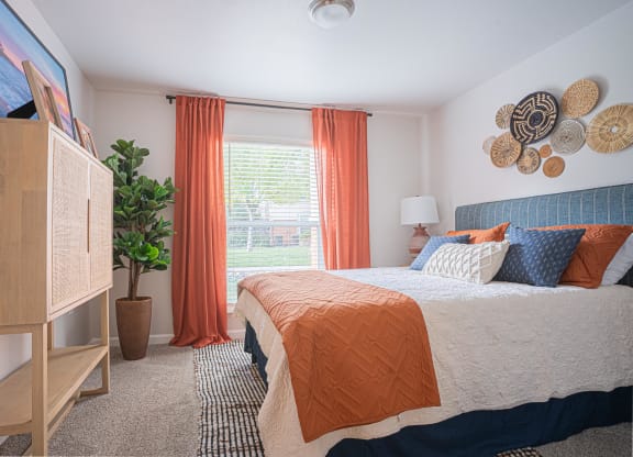a bedroom with a bed and a dresser and a window at Austin Crest Apartments, Reno, Nevada
