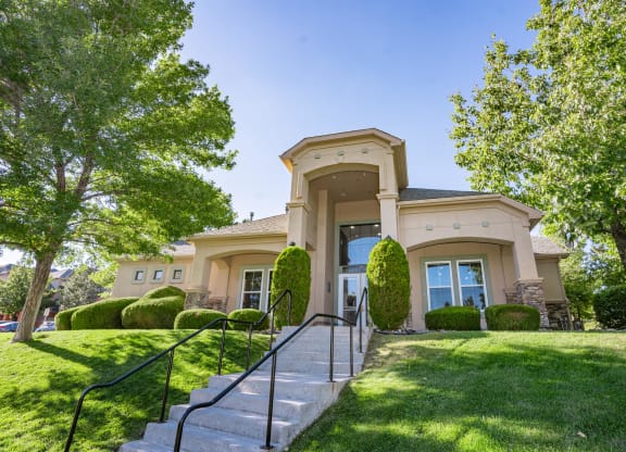the front of a house with stairs and grass and trees at Austin Crest Apartments, Reno