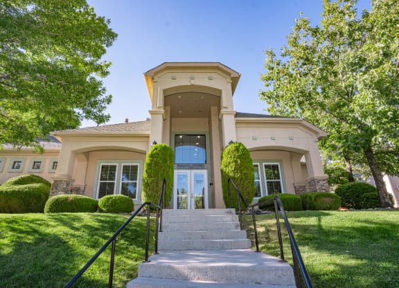 the front of a house with stairs and a lawn and trees at Austin Crest Apartments, Reno, NV