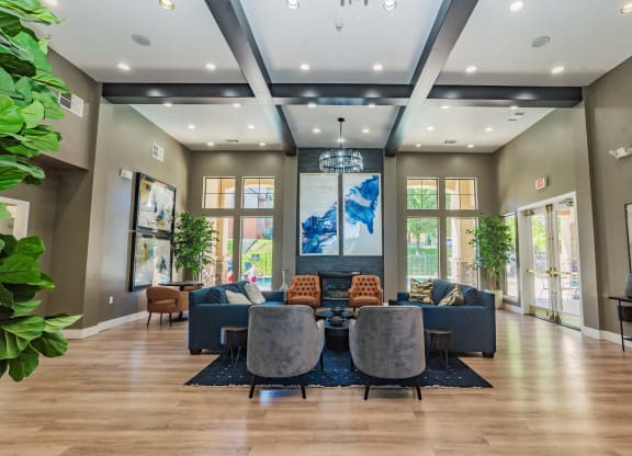 a large living room with a couch and chairs and a table at Austin Crest Apartments, Reno