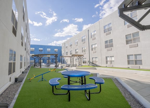 a playground and picnic area in the courtyard of an apartment building at The Onyx at 695, Reno, NV, 89503