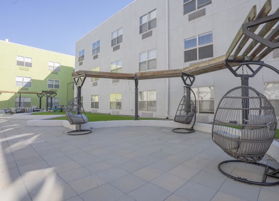 a courtyard with swing chairs in front of a building  at The Onyx at 695, Reno