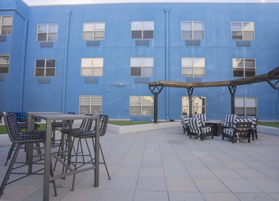 a patio with tables and chairs in front of a blue building at The Onyx at 695, Nevada