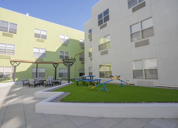 a courtyard with a playground and tables and chairs in an apartment building at The Onyx at 695, Nevada, 89503