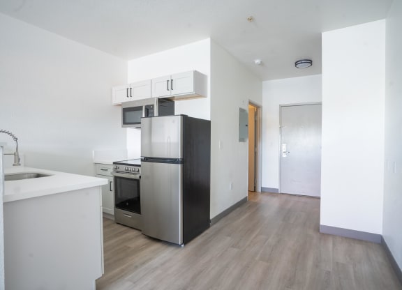 an empty kitchen with a refrigerator and a sink at The Onyx at 695, Nevada