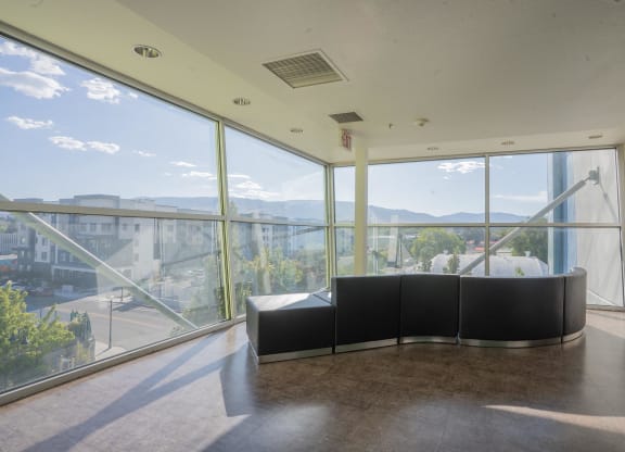 the lobby of a building with large windows and a black couch at The Onyx at 695, Reno, NV, 89503