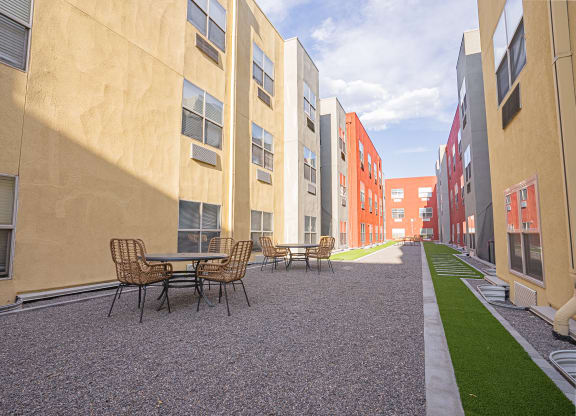 a courtyard with tables and chairs in a row of apartment buildings at ParcOne60, Reno, 89501