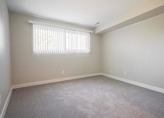 an empty living room with carpet and a window at Regency Park, Reno, Nevada