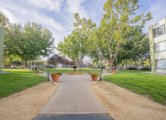 a walkway through a park between two buildings with grass and trees at Regency Park, Nevada, 89509