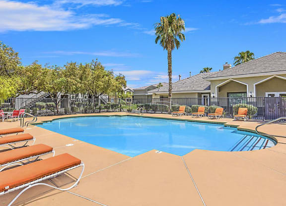 a swimming pool with chairs and a palm tree at Silver Creek Apartments, Las Vegas, NV, 89122