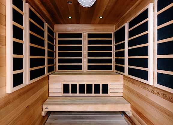A wooden sauna with a bench and a door.