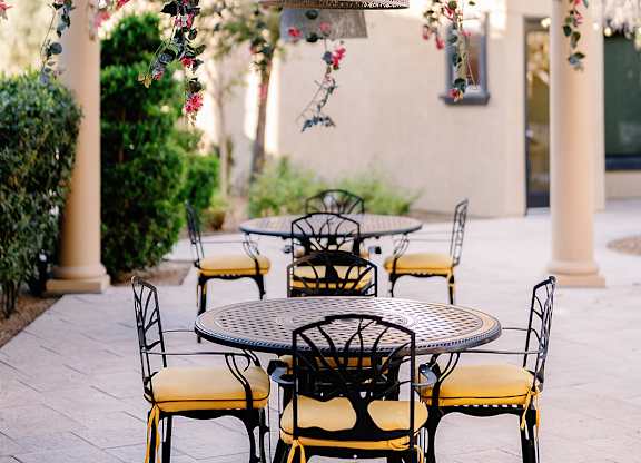 A table with chairs under a floral canopy.