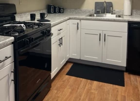 a kitchen with a stove a sink and a microwave at Monroeville Apartments, Monroeville