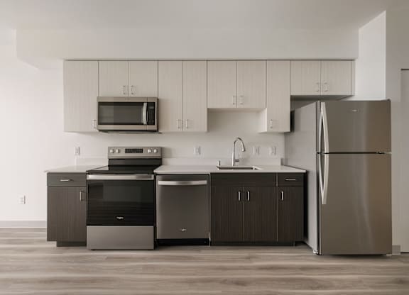 A modern kitchen with stainless steel appliances and wooden cabinets at Nook at Northaven Apartments, Seattle