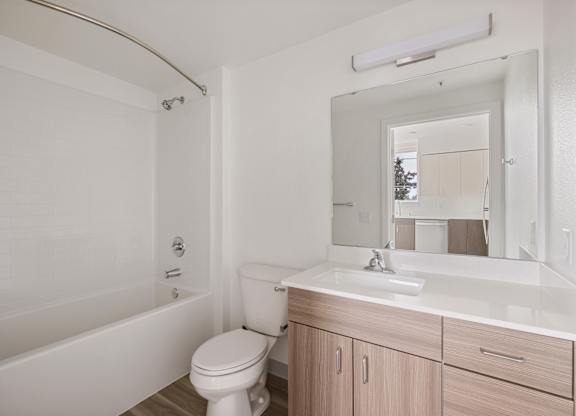 A white bathroom with a toilet, sink, and bathtub at Nook at Northaven Apartments, Seattle, Washington