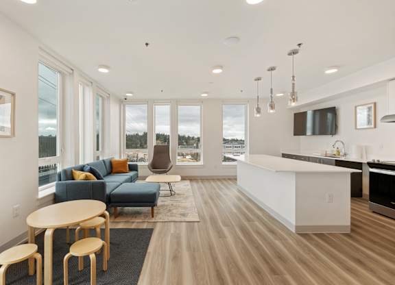 A modern living room with a blue sofa and wooden floors.