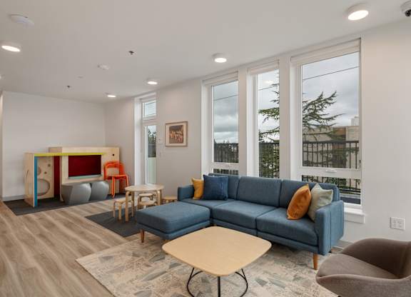 A living room with a blue couch and a wooden table.