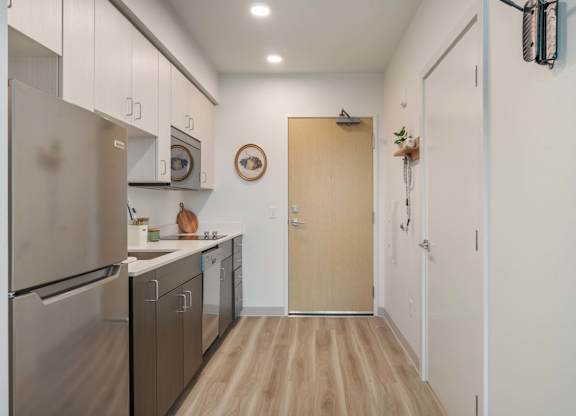 A kitchen with a refrigerator, microwave, and oven at Nook at Northaven Apartments, Seattle, WA
