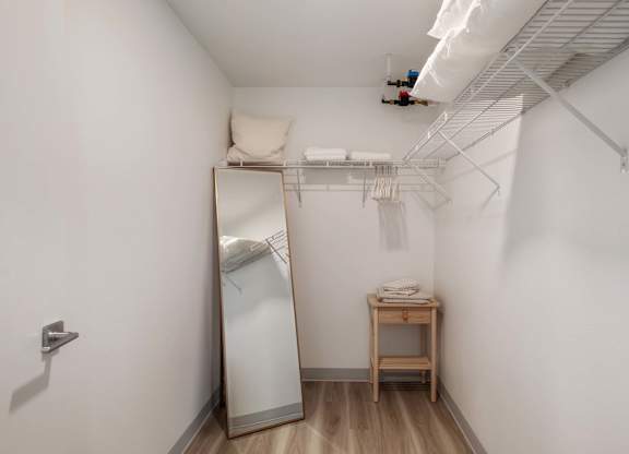 A small room with a mirror, a table, and a clothes dryer at Nook at Northaven Apartments, Seattle
