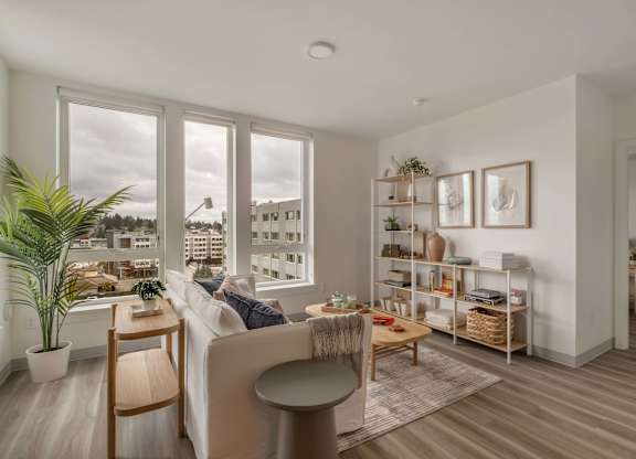 A living room with a couch, a chair, a table, and a potted plant at Nook at Northaven Apartments, Seattle, WA