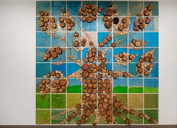 A painting of a tree made out of wood slices.