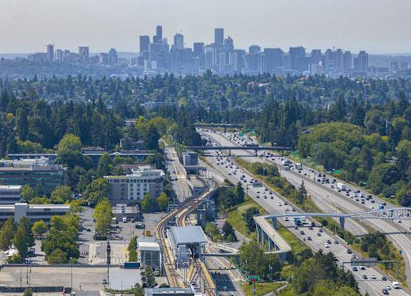 A cityscape with a highway and buildings in the background.