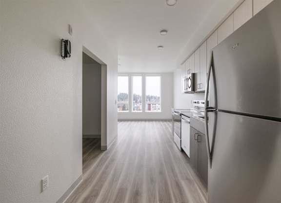 A modern kitchen with a refrigerator on the right side at Nook at Northaven Apartments, Seattle
