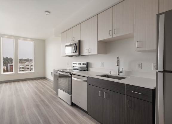 A modern kitchen with wooden floors and stainless steel appliances at Nook at Northaven Apartments, Seattle, WA
