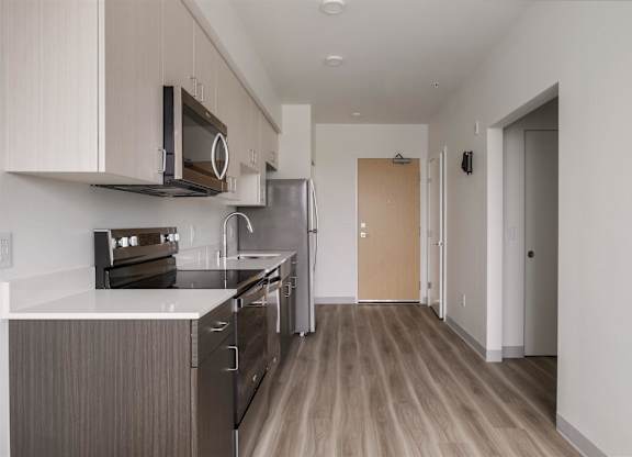 A kitchen with wooden floors and stainless steel appliances at Nook at Northaven Apartments, Washington
