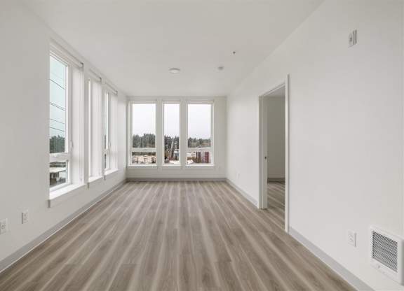 A spacious room with wooden flooring and large windows at Nook at Northaven Apartments, Seattle, 98125