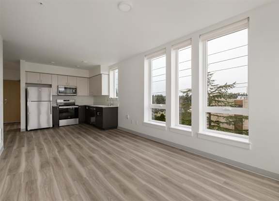 A kitchen with white appliances and wooden floors at Nook at Northaven Apartments, Seattle