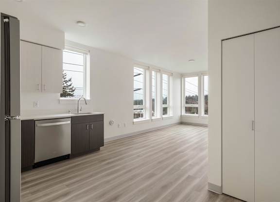 A kitchen with a refrigerator, sink, and cabinets at Nook at Northaven Apartments, Washington