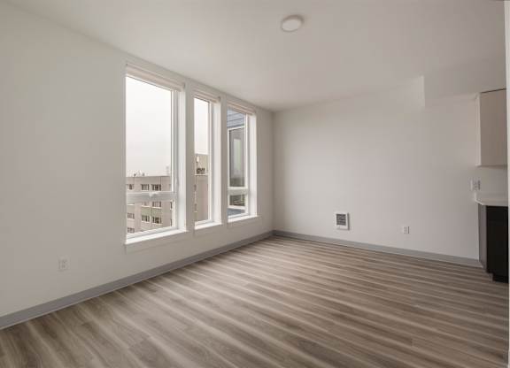 A room with a wooden floor and a window overlooking a cityscape at Nook at Northaven Apartments, Seattle